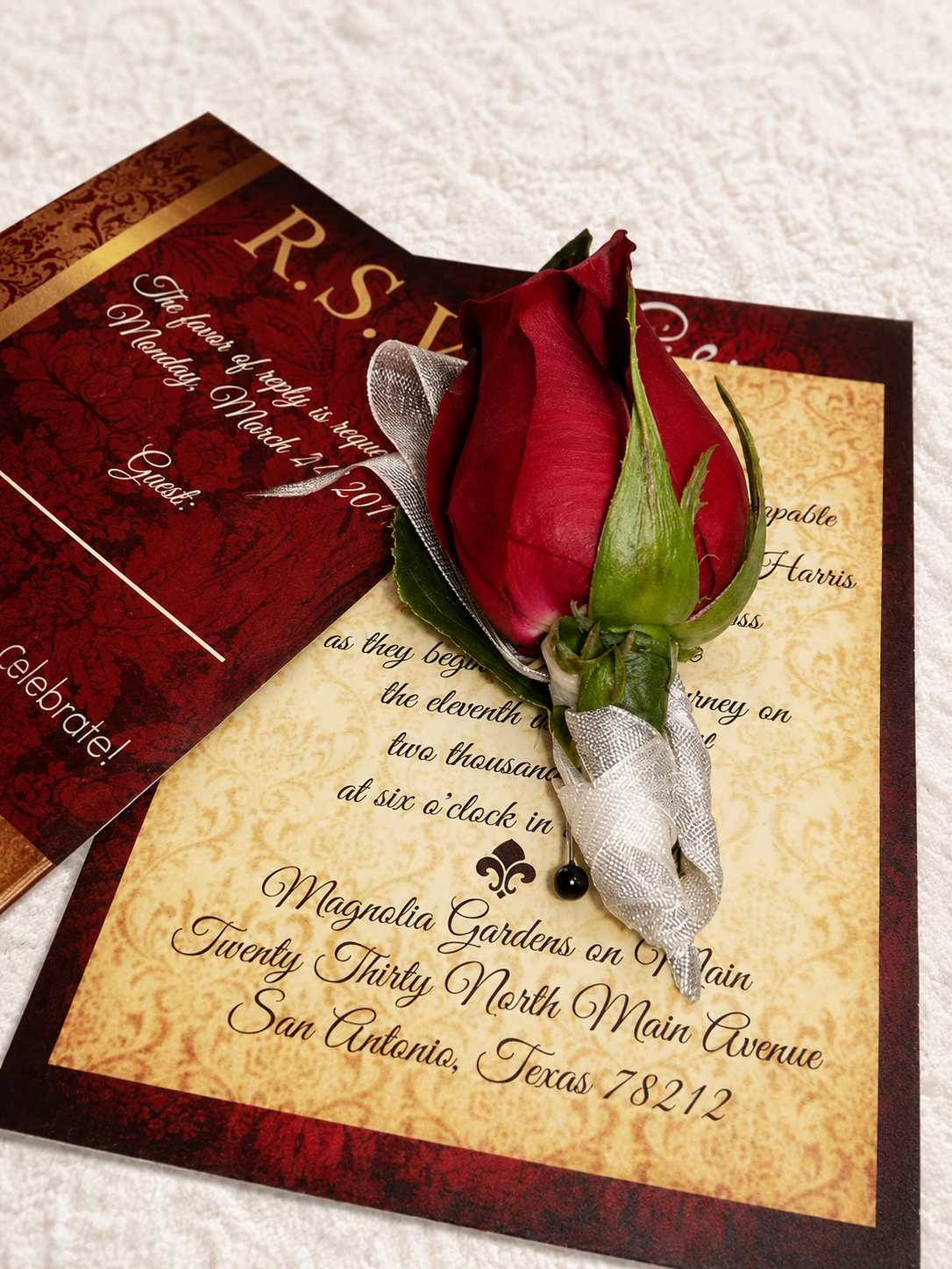 Elegant wedding invitation suite with red rose boutonniere on vintage parchment stationery